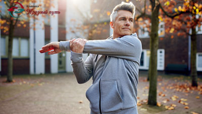 Мужчина делает зарядку на улице